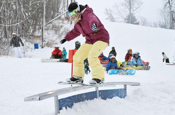 Sophomore Emma Dodd rides a rail at Marquette Mountain, the location of the Jam for Love fundraiser for the Lake Superior Village Youth and Family Center. The jam is judged by those riding, and there are classes for men’s ski, men’s snowboard and all females. // Photo courtesy of Mike Kvackay
