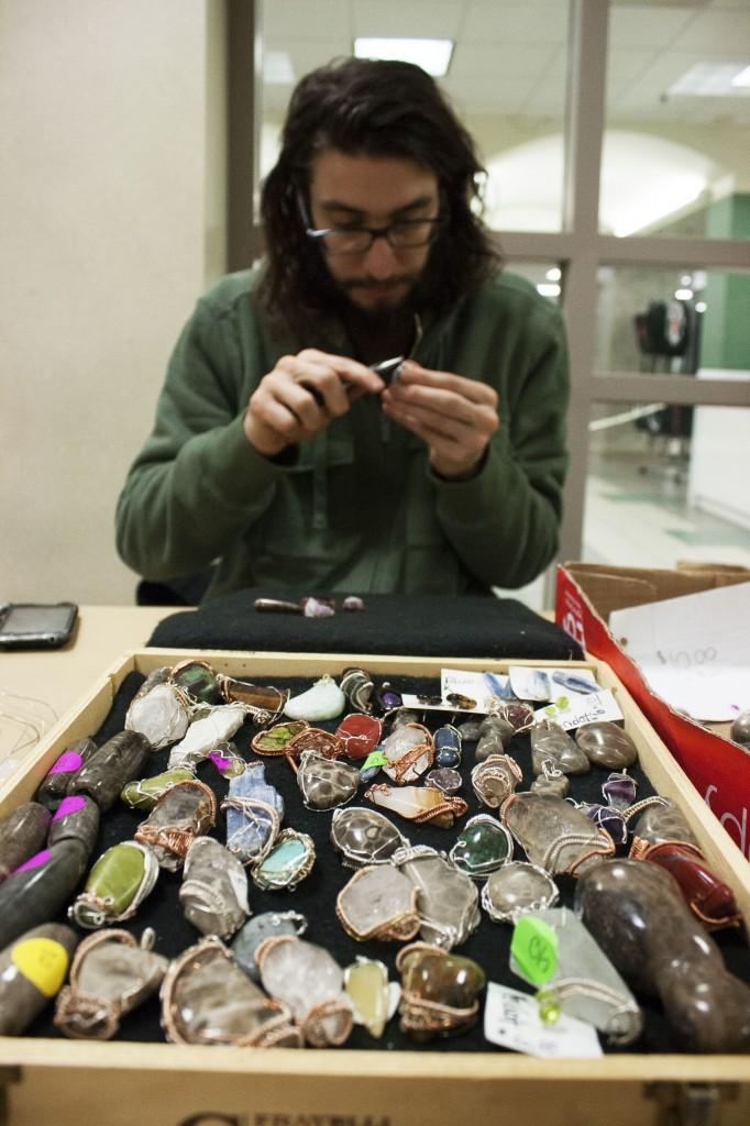 Greg Laskowski, junior environmental studies and sustainability major, sells wire-wrapped rocks and gems, which can then be used for jewelry. (Anthony Viola NW)
