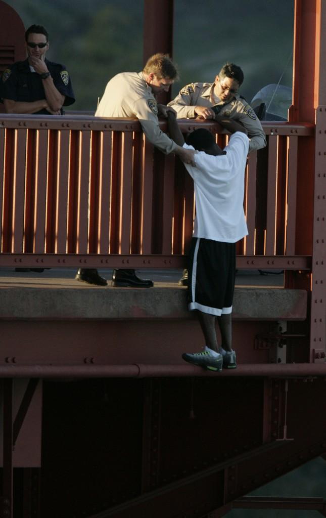 CHP Officer Kevin Briggs helps a jumper over the rail after they talked him down. A jumper, Kevin Berthia, is talked down by CHP officer Kevin Briggs, center, at the north tower of the Golden Gate Bridge.

(John Storey: San Francisco Chronicle)


