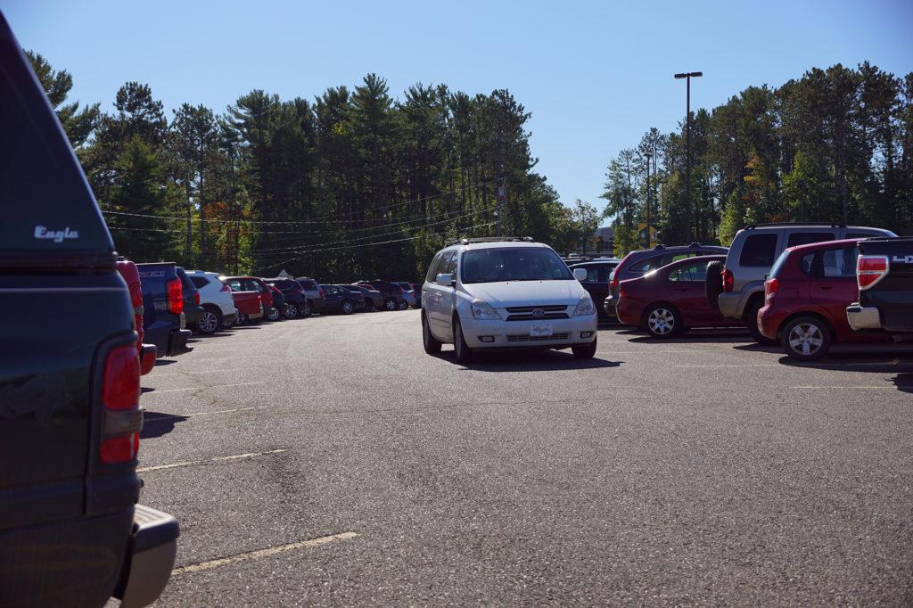 Photo by Kat Torreano: A car circles Lot 11. Lot 11 holds parking space sections for students, faculty and staff, according to the most recent parking map. 