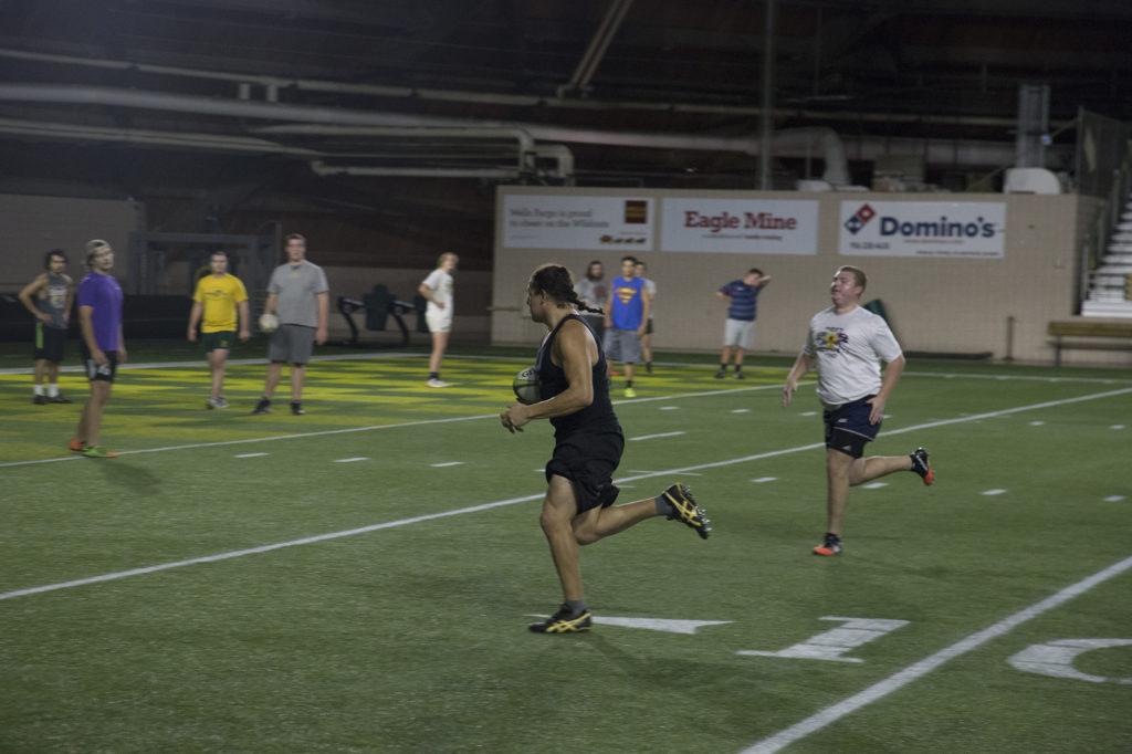 Photo by Neil: Senior English writing major Alberto Flores runs with a Rugby ball also known as a “quanco.”  A traditional quanco is made  of pig bladder and is diamond shaped to make it easier to throw.