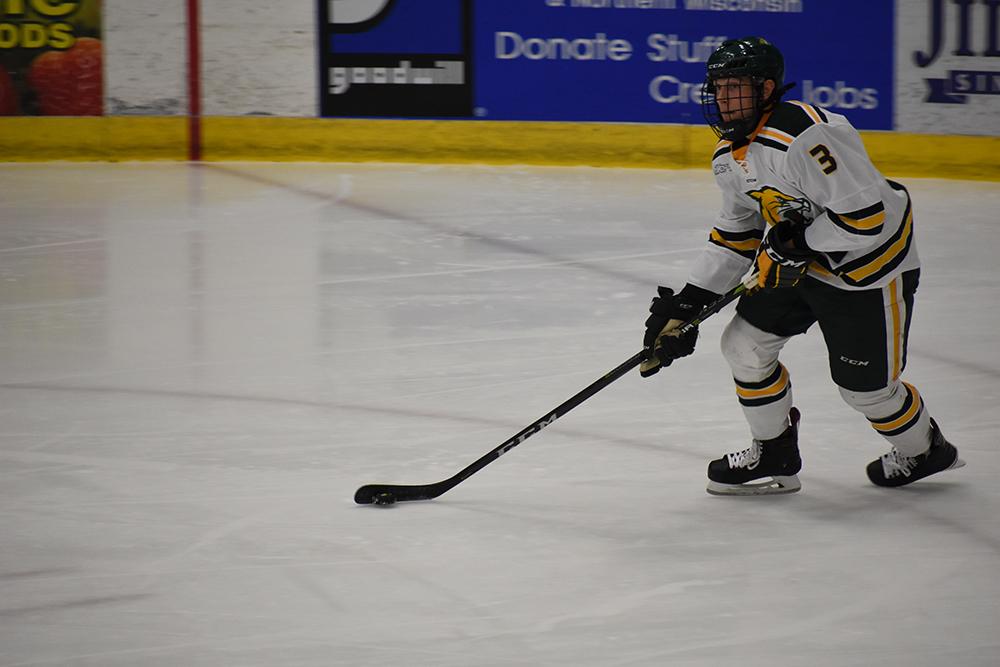 Freshman defenseman Robert Fosdick carries the puck up from behind the NMU net. Fosdick has four points this season through 24 games played, including one goal.
