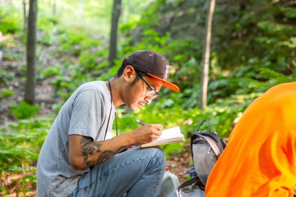 Guiancarlo “Carlo” Estupigan sketches in a notebook. The 25-year-old sophomore fish and wildlife management major was found dead Sunday near the Yellow Dog River after missing for three days.  
Photo courtesy of NMU Marketing and Communications Office.