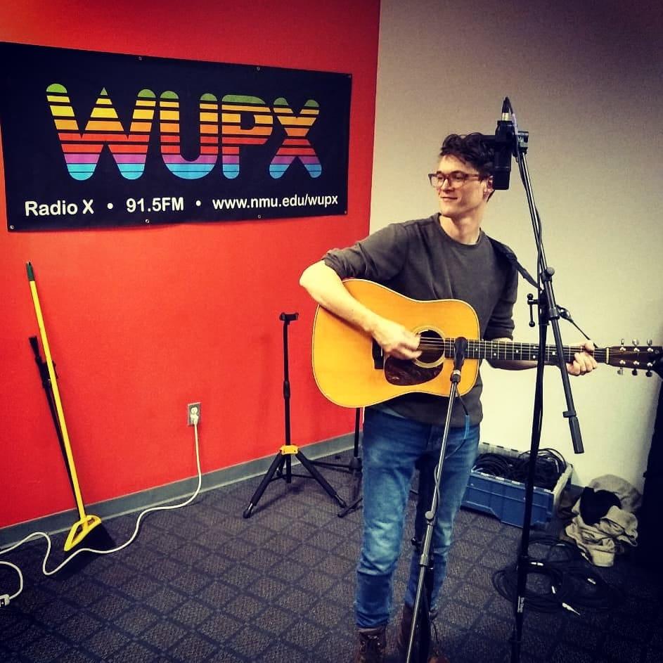 Photo courtesy of the Radio X Facebook Page 
LIVE JAMS—Local musician John Davey performs during Live at the X, a segment where musicians come into the studio to perform on air. 