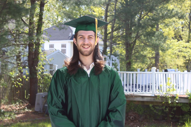 Adam Litsky posing in his highschool cap and gown, edited by his girlfriend to be northern green