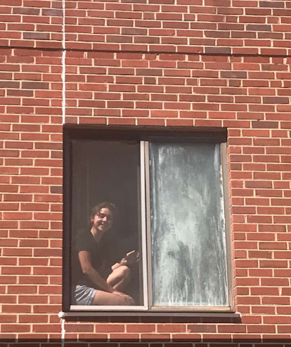 Student sitting in a window during quarantine