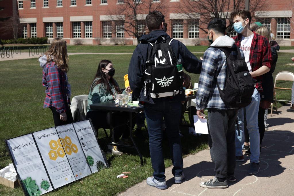 EcoReps talk to students at outdoor table for Earth Fest 2021.
