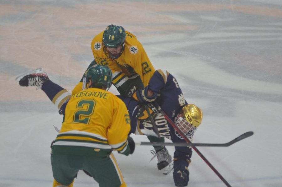 LUCK OF THE IRISH—NMU forward Connor Marritt and defenseman Trevor Cosgrove collide with Notre Dame forward Grant Silianoff in the first period of Saturday night's game. The 'Cats came up short 5-2 against the Fighting Irish, and didn't get good bounces throughout the game. Travis Nelson/NW