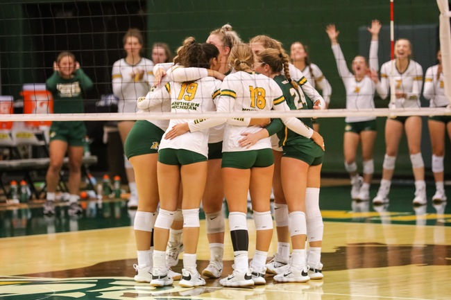 HOME SWEET HOME— The NMU Volleyball team huddles up after scoring a point while the bench celebrates behind them. A few of NMUs sports teams had an eventful weekend at home for homecoming. Photo courtesy of NMU Athletics