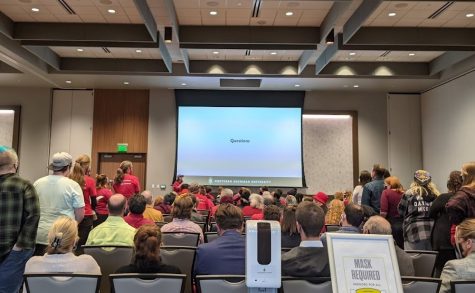 QUESTIONS?—Long lines of students, faculty and community members stand before microphones at the Oct. 26 university forum. So many people were in attendance that the room was expanded to meet fire code.