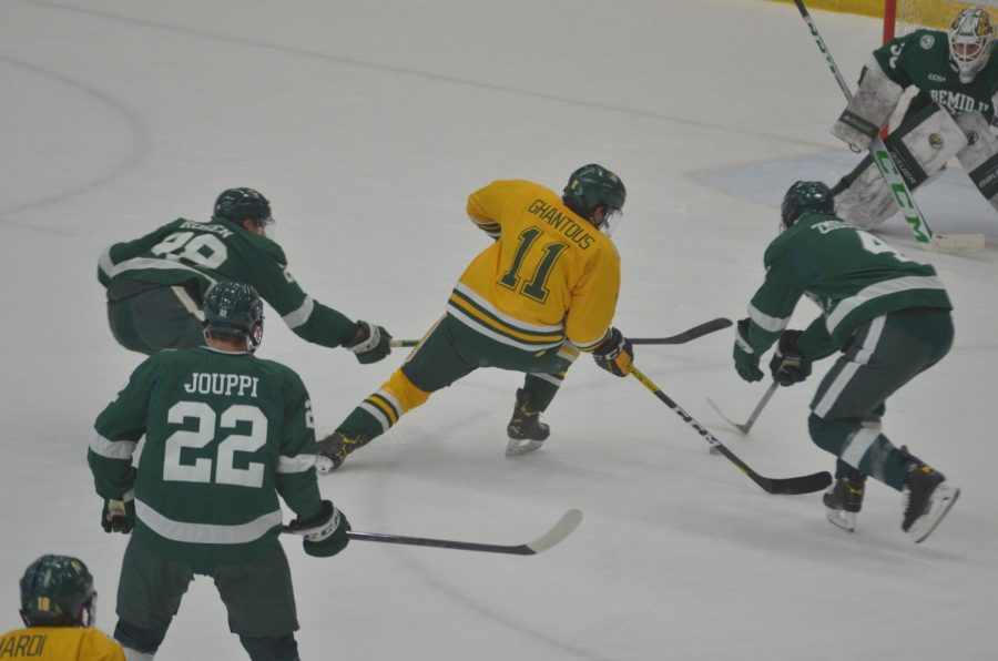 GETTING BACK ON TRACK—NMU forward Andre Ghantous carves through the Bemidji State with a goal on Saturday, Oct. 23. After losses to highly ranked opponents, both the Wildcat hockey and football teams try to find wins this weekend.