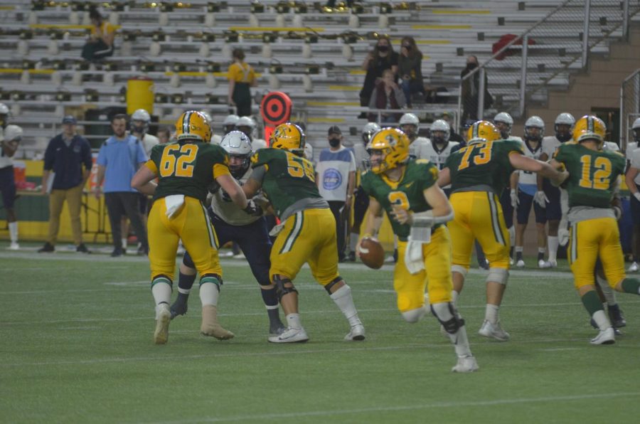 GOING OUT ON TOP—NMU quarterback Zach Keen rolls out of the pocket to make a throw during Saturday's win over Northwood. Despite being shorthanded and trailing early, the 'Cats closed the season out strong. Travis Nelson/NW.