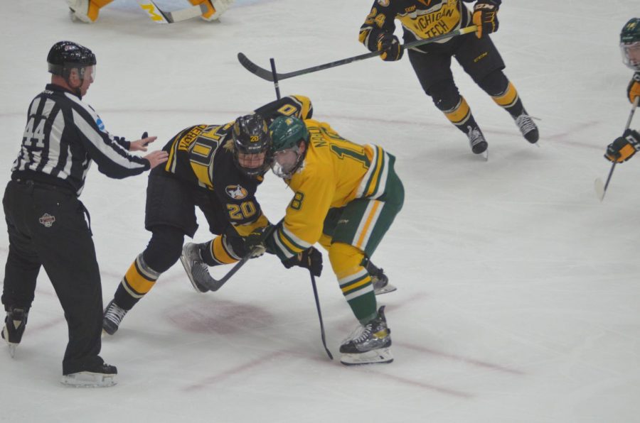 RIVALS GOING AT IT—NMU forward Joseph Nardi fights for the faceoff with Michigan Tech's Arvid Caderoth during Saturday night's game. The Wildcats lost 5-2, but earned the series split with a win on Friday. Travis Nelson/NW.