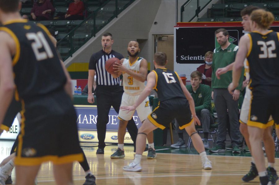 RIVALRY BATTLE—NMU guard Justin Brookens surveys the Michigan Tech defense during the 64-62 rivalry loss on Monday night. Travis Nelson/NW
