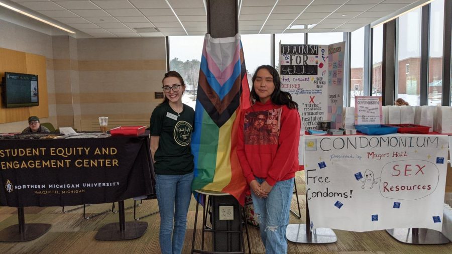 SAFER SEX - Devin Ziembiec (left) and Reyna Defoe (right) stand in front of the tables for Condomonium in Jamrich Hall. They passed out numerous educational pamphlets, latex-free condoms, dental dams and other sexual education materials.
