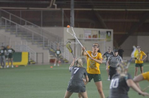CLAWING TO THE FINISH—NMU midfielder #12 Madeline Bittell rifles a pass to a teammate during the Wildcats 13-10 loss to Concordia St Paul on Wednesday, April 13. NMU closes out the regular season this weekend against Davenport and Grand Valley State. Travis Nelson/NW
