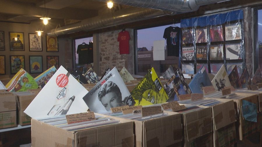 Records sticking out of boxes in a row on tables.