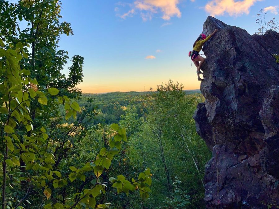 CLIMB HIGH — A climber scales up Slugg’s Bluff, an 80-foot tall quartzite cliff located in the Upper Peninsula. Slugg’s Bluff is the first climber-owned area in Michigan, with the Upper Peninsula Climbers Coalition recently being gifted the land.