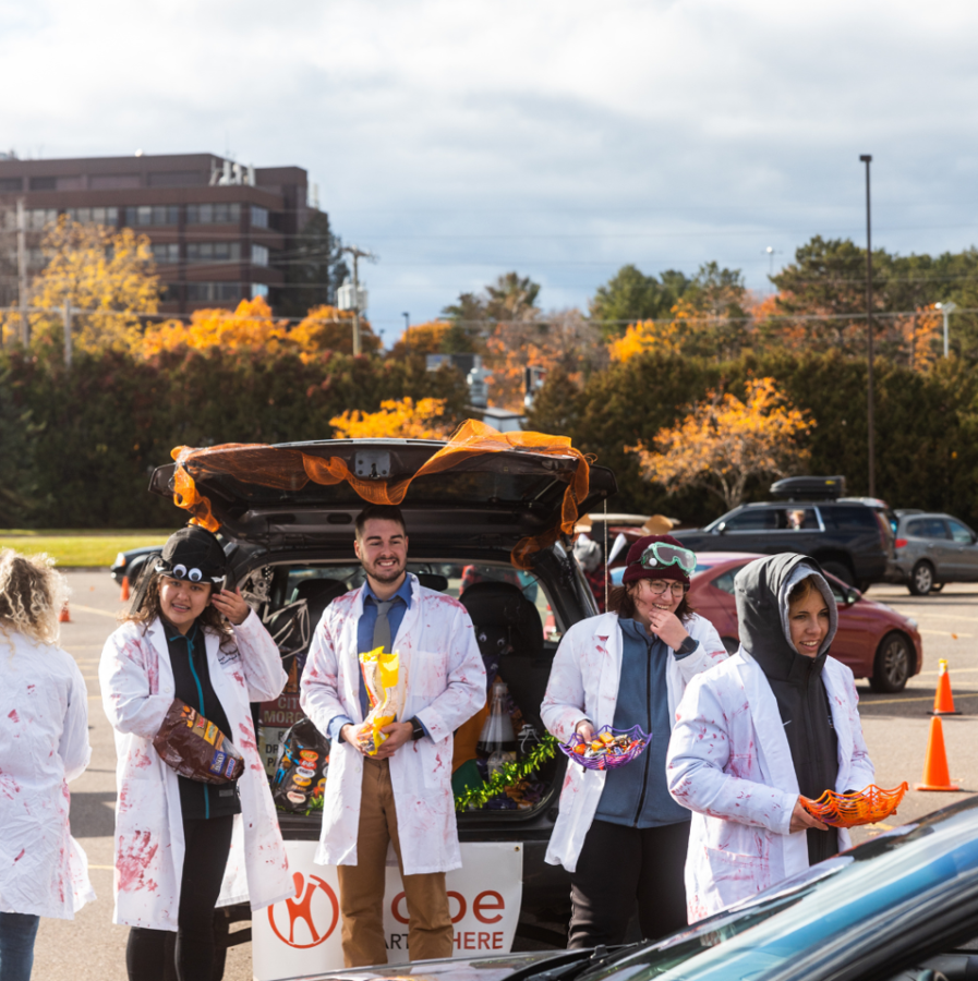 TREATS GALORE — Students hand out candy to a passing vehicle at last year’s Trunk or Treat event. The Special Events Committee will be hosting its third annual Trunk or Treat on Oct. 29, offering community members a twist on traditional trick-or-treating that is more convenient and accessible. 