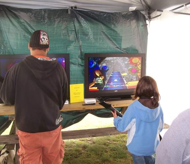 COMPETITOR — A picture of 8-year-old me (right) competing in a Guitar Hero contest at a fundraiser event in my hometown. Along with being the only child in the competition, I was also the only female. Despite this, I battled my way to the final four, knocking out two men before falling myself.