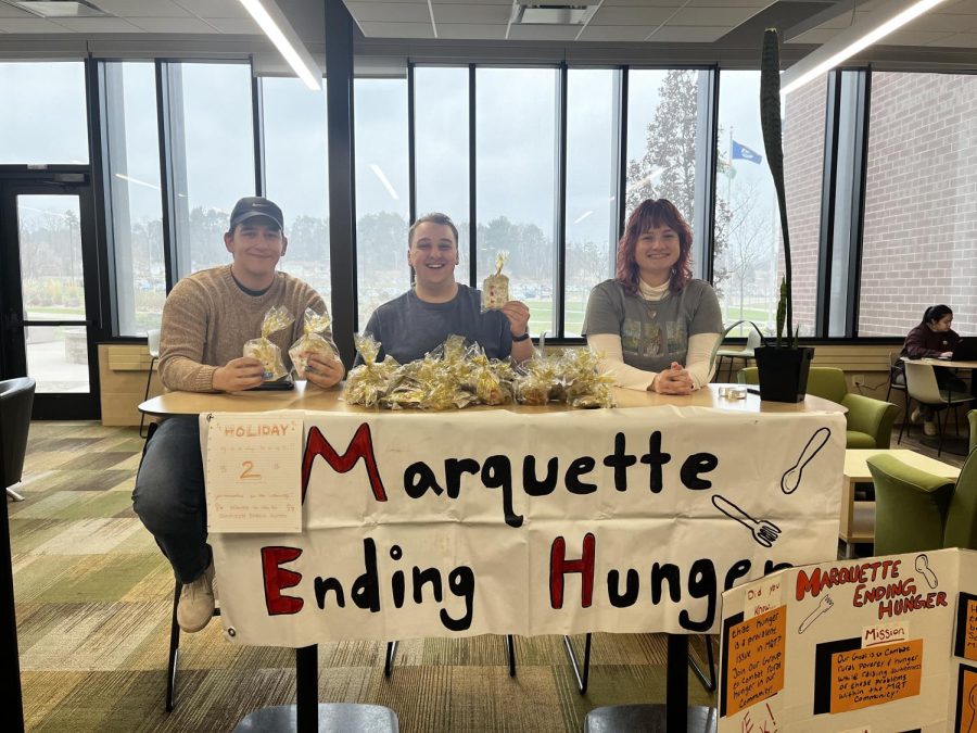 FUNDRAISER FOR FOOD — Marquette Ending Hunger members Dallas Wiertella (left), Patrick Myers (center) and Sydney Butler (right) sell goodie bags in Jamrich on Nov. 29 for the TV6 canathon. All the money and food donated to the canathon go to support food pantries and families in need throughout the UP.