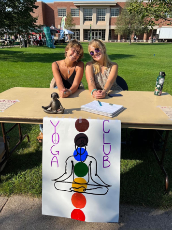 NEW HORIZONS — Olivia Apa (left) and Anna Fry (right) talk to prospective members at Fall Fest 2022. Apa and Fry started Yoga Club in partnership with Unity Yoga Co-op in downtown.