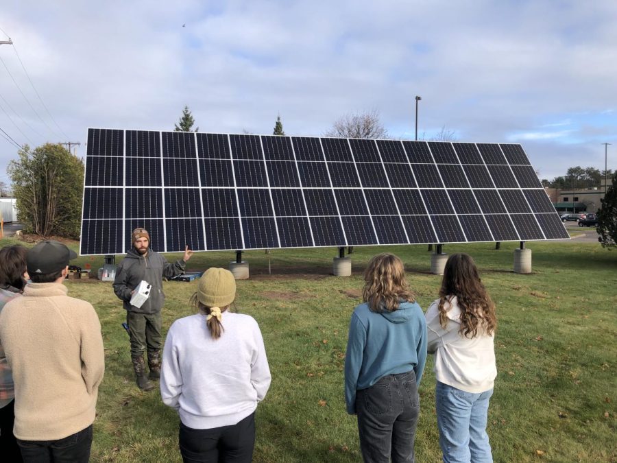 SUN POWER — NMU students listen as a member of the solar panel installation crew explains how the bifacial panels work. The fully operational panels, located next to the SHINE building on Presque Isle Avenue, are the largest project to be financed entirely by the Green Fund, a five-dollar per semester student-paid fee.