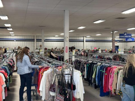 TRASH OR TREASURE — Customers flip through racks of clothing at the Marquette Goodwill. Not only is thrift shopping an incredibly relaxing experience, but buying items second-hand is great for our environment.