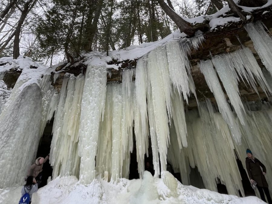 SNOWBOUND — Visitors admire the Eben Ice Caves, located just north of Chatham, after a brief hike. While more popular in the summer and fall, the outdoor recreation areas in and around Marquette house many winter wonders to be enjoyed.