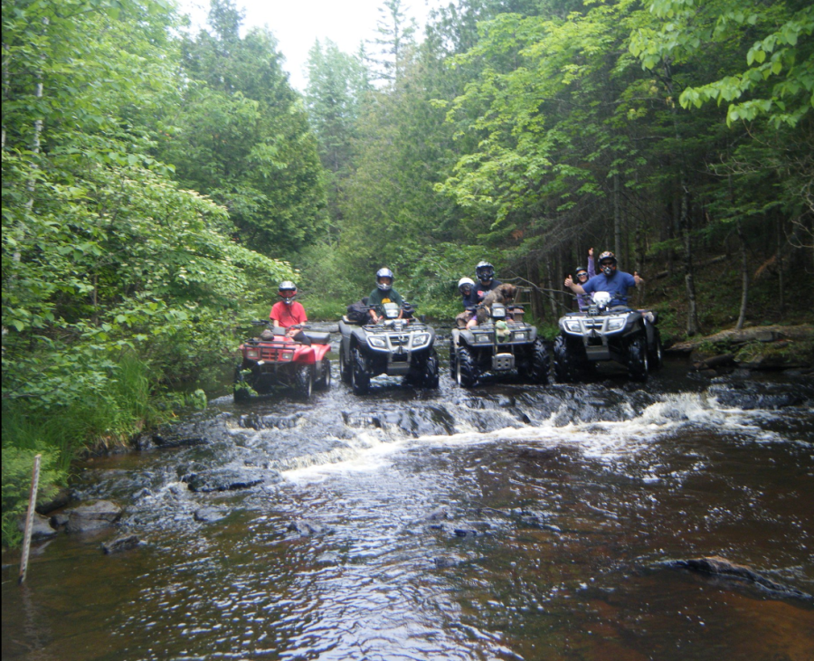 CONVOY — Our four-wheeling group sitting in the middle of a shallow stream during one of our off-roading expeditions (I am the one giving the big smile and thumbs up on the far right). When planning a four-wheeling trip, we would always map our route so we could visit as many landmarks as possible.