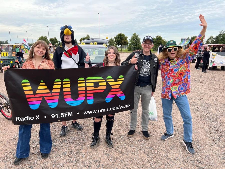 WUPX RADIO X — Members of Radio X attend the NMU 2022 homecoming parade. From left to right, Lauren Lahtinen, Owen Voisinet, Julia Emery, Alex Watanen and Mark Shevy.