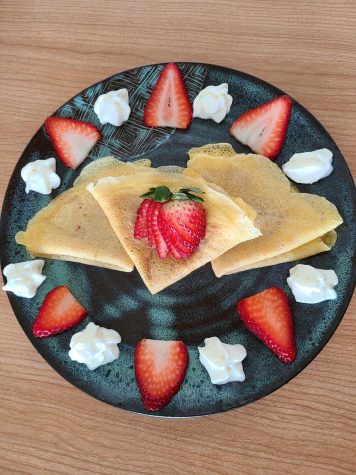 STRAWBERRY CREPES — An arrangement of my crepes filled with homemade strawberry rhubarb jam and ringed with fresh strawberries and whipped cream. I also experimented with strawberry garnishes that I discovered on YouTube.