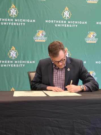 OFFICIAL SIGNING — President Brock Tessman formally signs the Okanagan Charter on April 26. The charter is a commitment by NMU to support and implement holistic health programs and initiatives for students, staff and faculty.