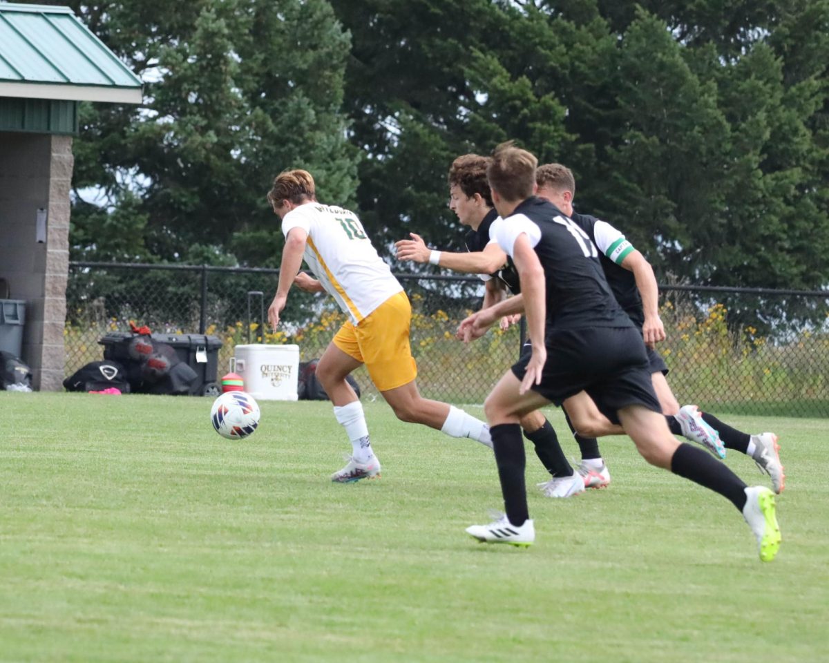 DRAWING ATTENTION — Sophomore Tommaso Lami speeds down the field with three defenders guarding him. Lami found the lone goal for the Cats in the 1-0 win against Quincy. NMU was able to follow that with a draw against a tough Lewis team on the road.
