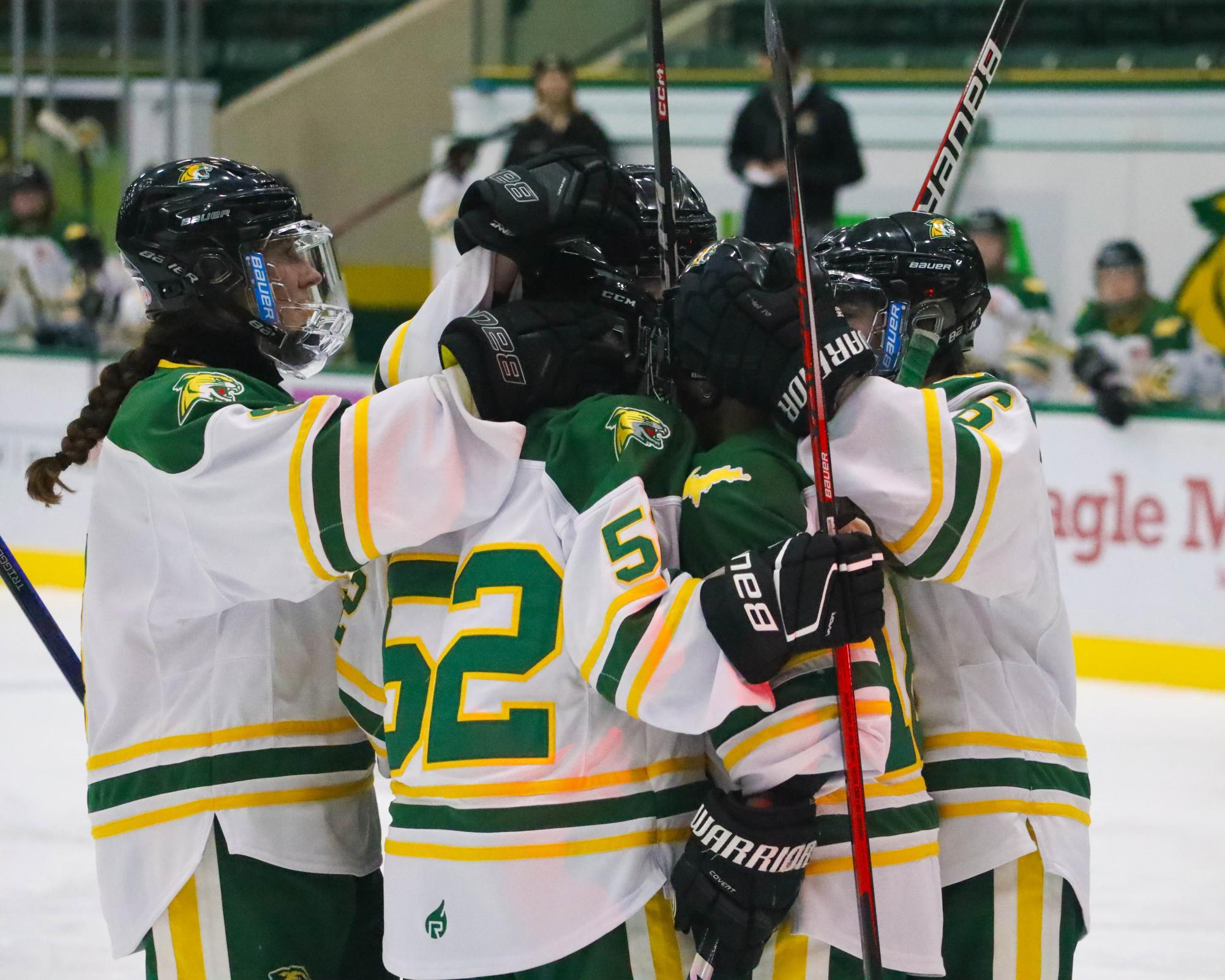 HOME SPLIT — The Northern Michigan womens ice hockey team celebrates win against rival Bulldogs. 