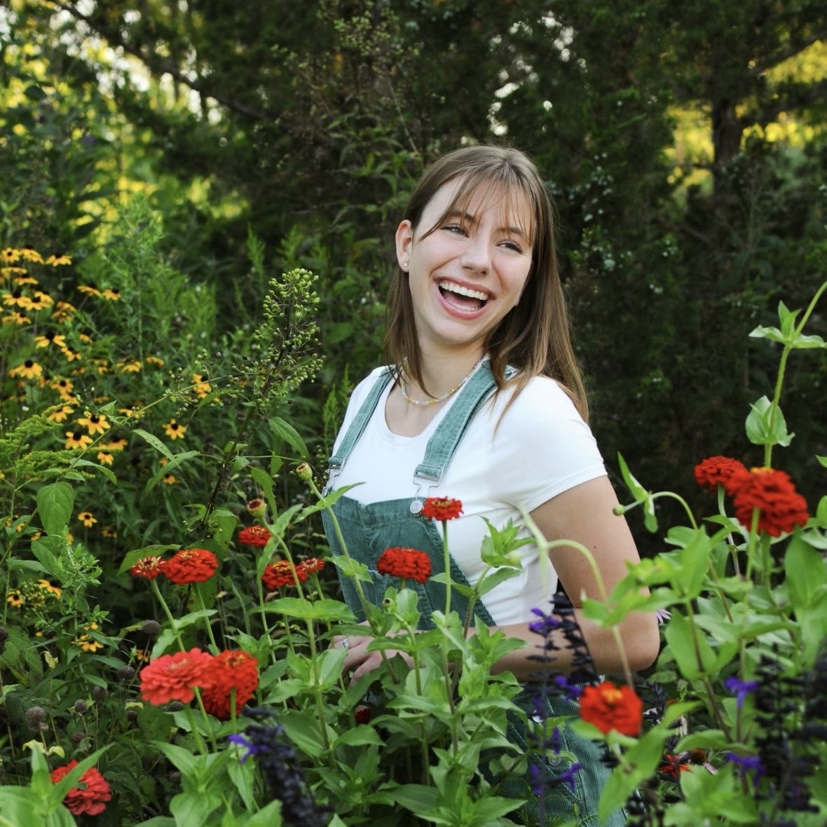 BIG SMILES —Evie Weiszhaar poses in a vibrant flower garden.
