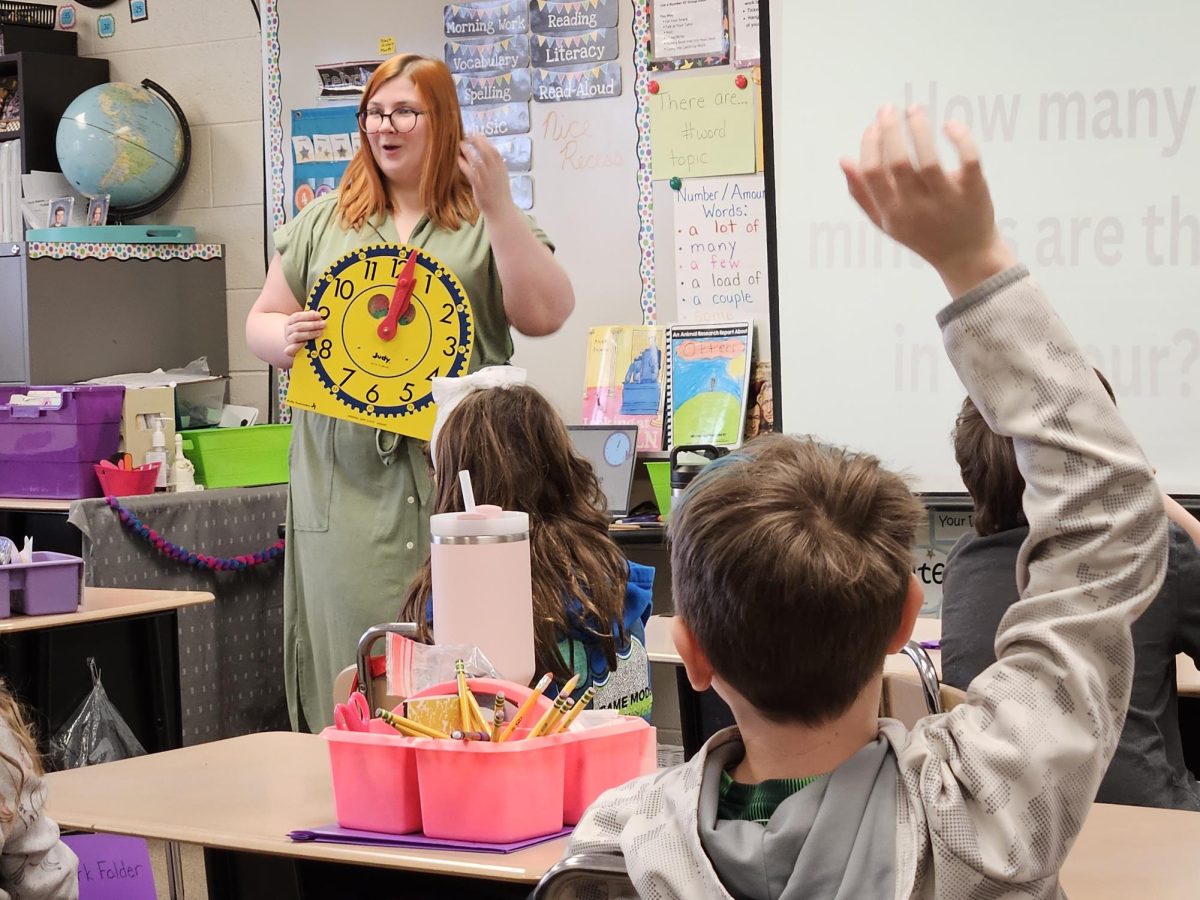 HANDS UP — A student raises his hand as Miller teaches surrounding students in her class. Photo Courtesy of Miranda Miller