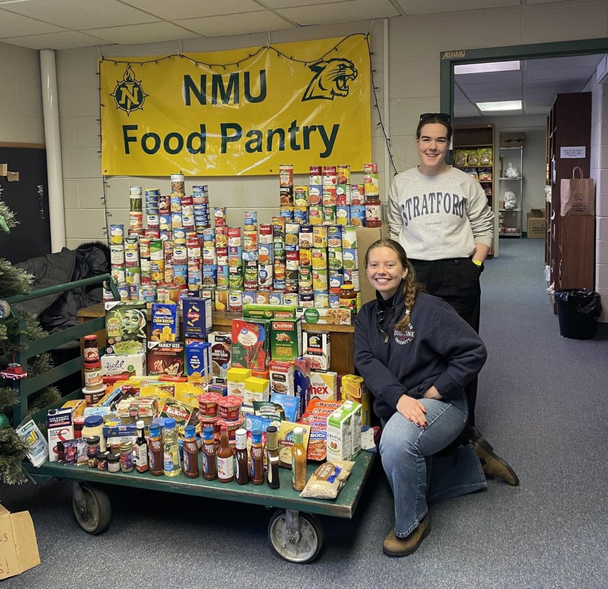 A PROUD COLLECTION — Carico (front) and Mary Kelly (back) pose in front of their food pantry collection. Photo Courtesy of Madison Carico