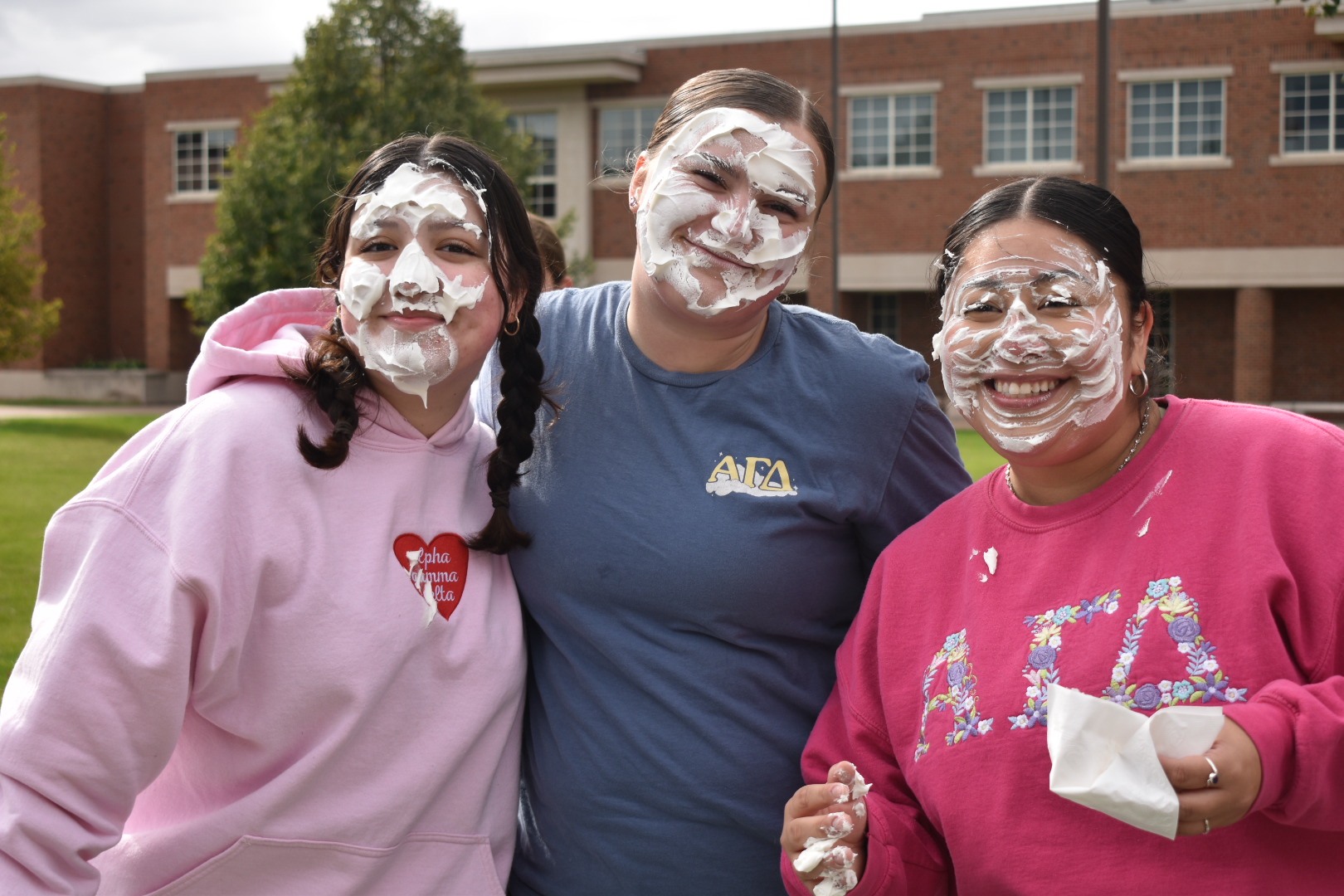 MESSY SMILES — NMU students pose with whipped cream-covered faces after being pied.