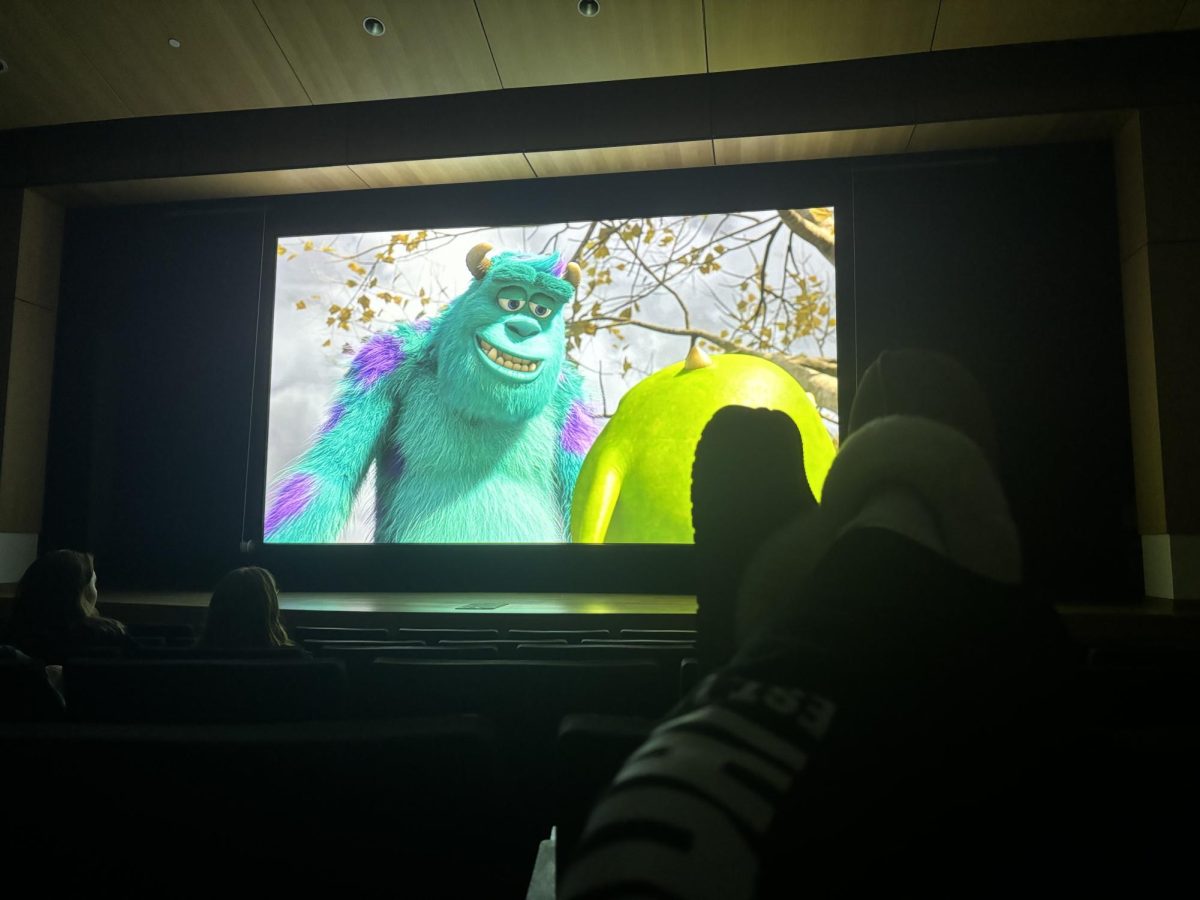 TAKING A SEAT — A student relaxes in Jamrich Hall to watch "Monsters University" through a collaboration between Campus Cinema and Greek Council.