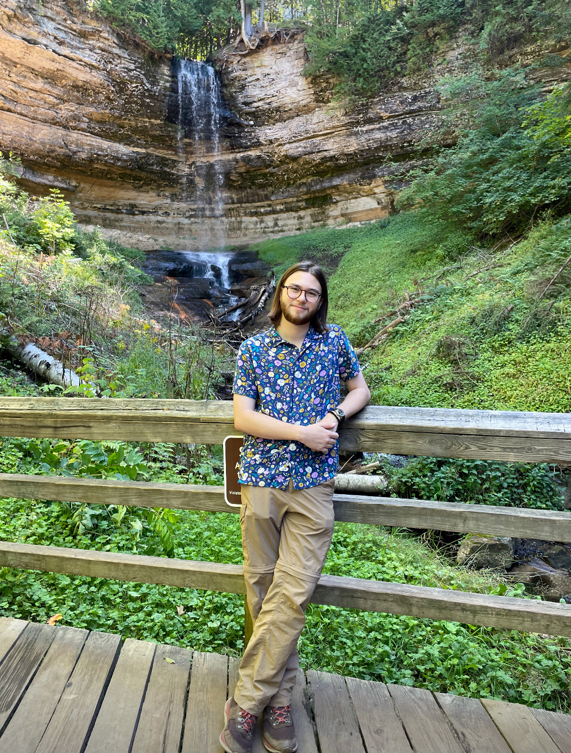 STOP AND SMILE — Student and Rocks and Mineral Club Vice President Thaden Weeks stops and poses in front of a waterfall. This is one of the many different places he stops to teach and learn about geology. (Photo courtesy of Thaden Weeks.)