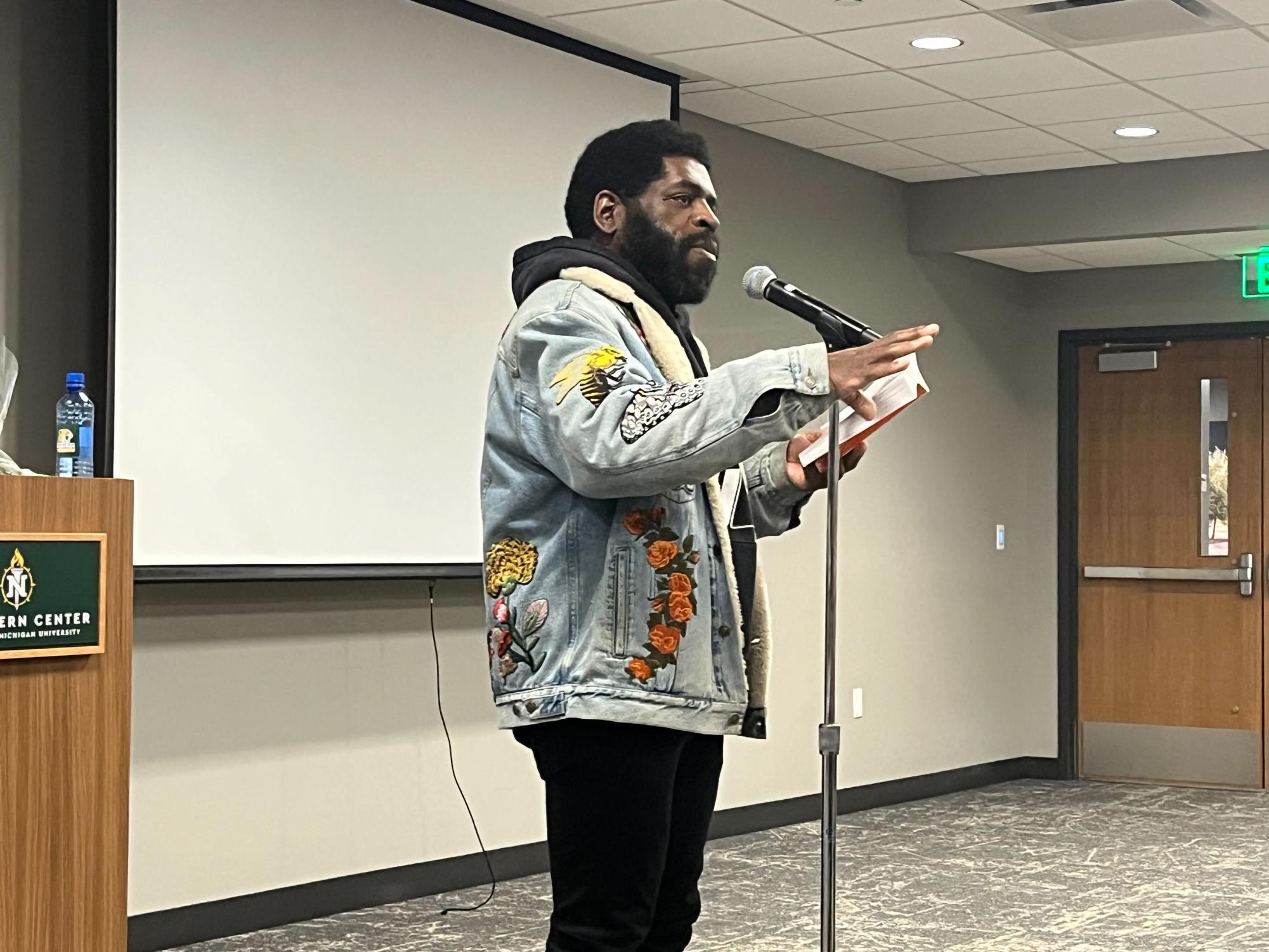 TELL YOUR STORY -  Hanif Abdurraqib stands before his audience, inspiring them with his words. 