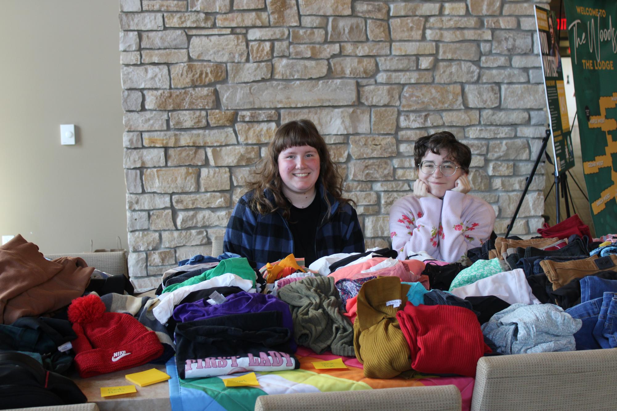 SHOP UNTIL YOU DROP – Queers and Allies members Abigail Strassburg and Cameron Jenerou displayed many different types of clothing in the Woods Lodge for students to buy. 