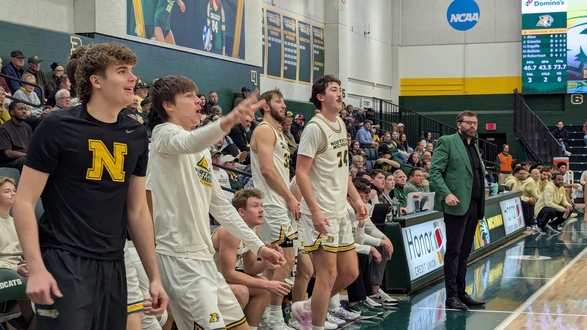 GIDDY WITH ANTICIPATION—  The Men's Basketball bench waits with baited breath for yet another triple to fall through.