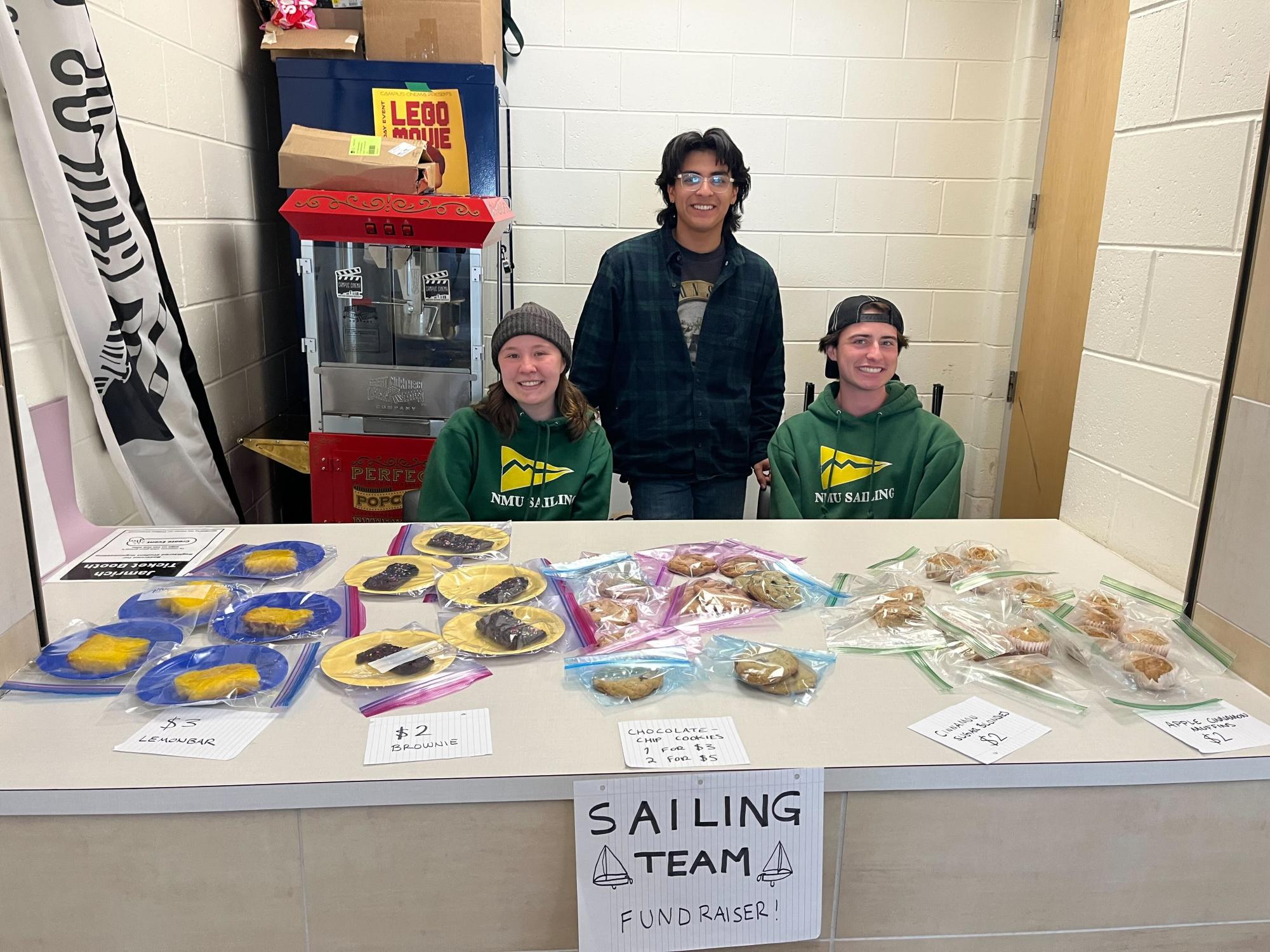 NMU Sailing team poses in front of their bake sale.